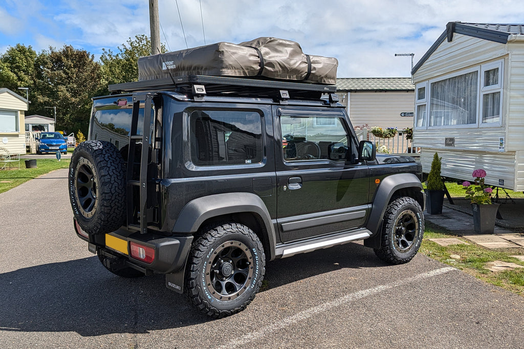 Suzuki Jimny 2018+ with XTREME-J XJ03 Wheels and a Front Runner Roof Rack, Rear Ladder and Roof Tent.